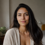 Autenticidade e amor-próprio: como acolher quem você é Mulher em casa olha para a câmera com expressão tranquila e natural.